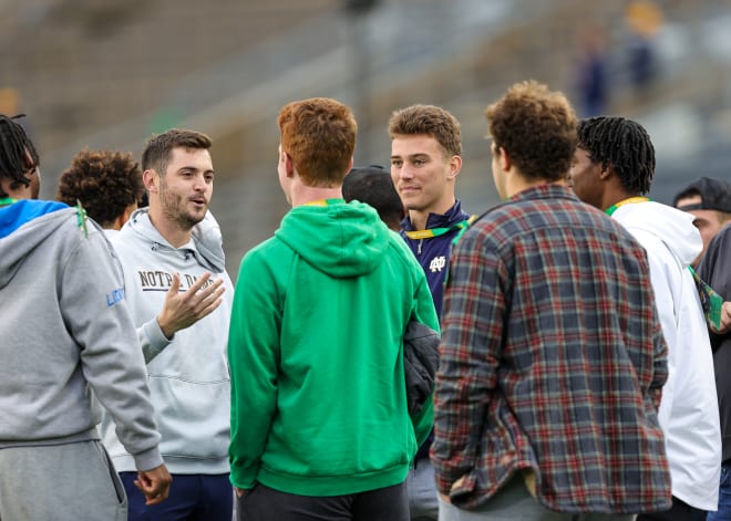 Notre Dame offensive coordinator Tommy Rees (left) chats with future Irish QB CJ Carr (blue jacket) and other recruits before ND's Nov. 5 showdown with Clemson.