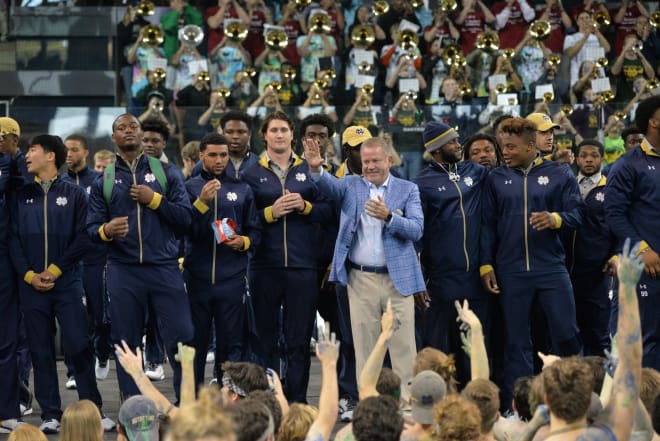 Brian Kelly salutes the crowd before last night's pep rally for Stanford.
