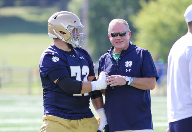 Notre Dame junior right tackle Robert Hainsey talks with head coach Brian Kelly before practice.