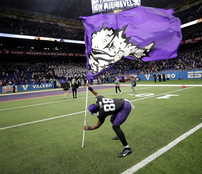 TCU's Artayvious Lynn plants the team's flag after defeating Stanford in 2017.