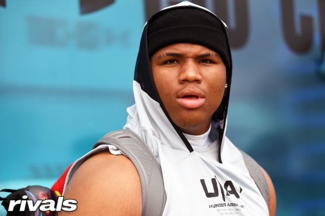 Five-star defensive tackle Walter Nolen holds a Michigan Wolverines football recruiting, Jim Harbaugh.
