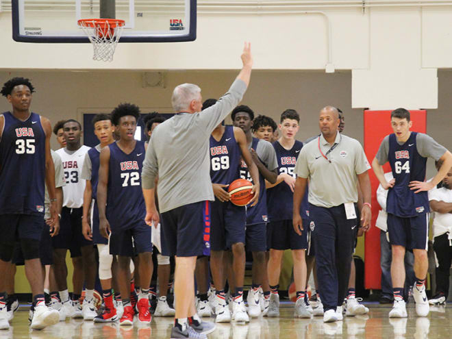 Athletes look on as USA head coach Don Showalter puts in a play.