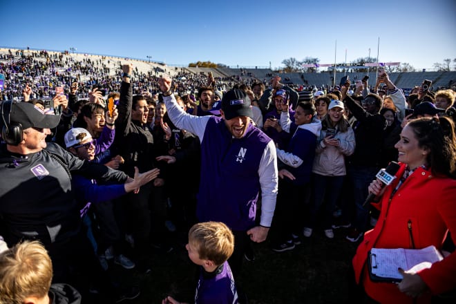 Head coach David Braun celebrates with his family and the fans after beating Purdue.