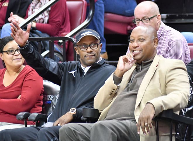 New FSU football coach Willie Taggart gives a chop to the fans while sitting between Stan and Ramona Wilcox at Wednesday's men's basketball game.
