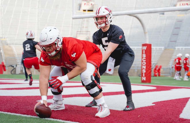 Quarterback Graham Mertz works with center Kayden Lyles during Wisconsin's 2021 spring camp