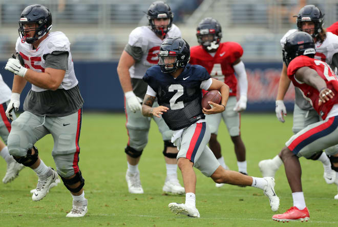 Quarterback Matt Corral (2) runs to daylight Sunday as offensive linemen Ben Brown (55), Nick Broeker (64) and Jeremy James (right) provide protection.