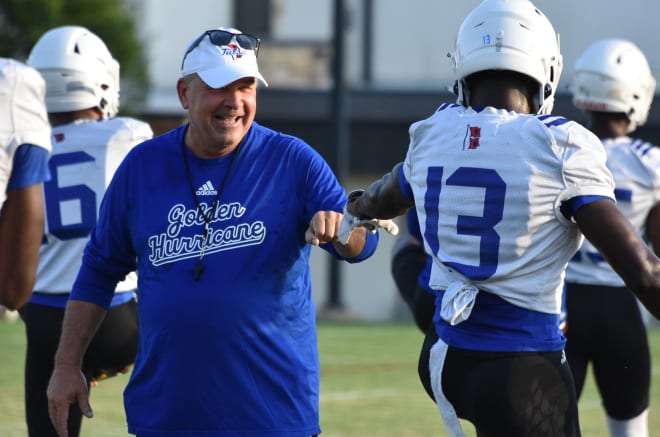 Tulsa coach Kevin Wilson interacts with players during the first preseason practice.