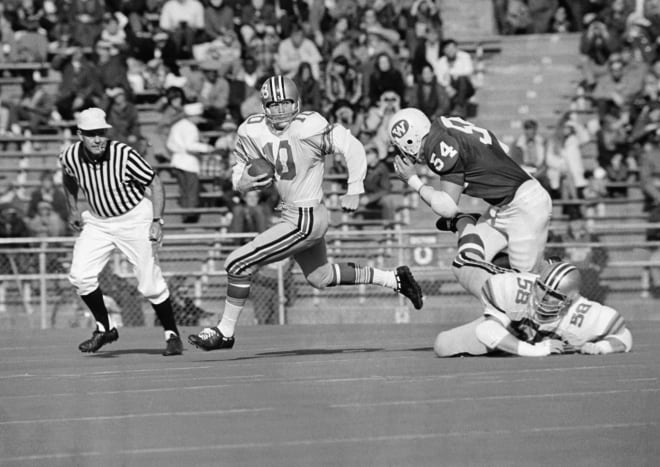 Ohio State's quarterback, Rex Kern (10), is pursued by University of Wisconsin's Gary Buss (54) during game action in Madison, Wis., Nov. 9, 1970. Kern had to scramble when he could not find an open pass receiver. Guss was tripped up by Ohio's Charles Bonica (58).
