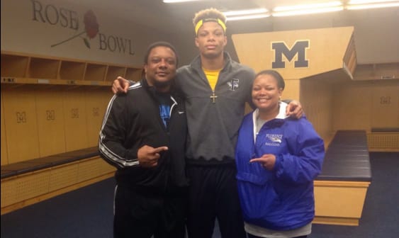Woods flanked by his parents in the U-M locker room.