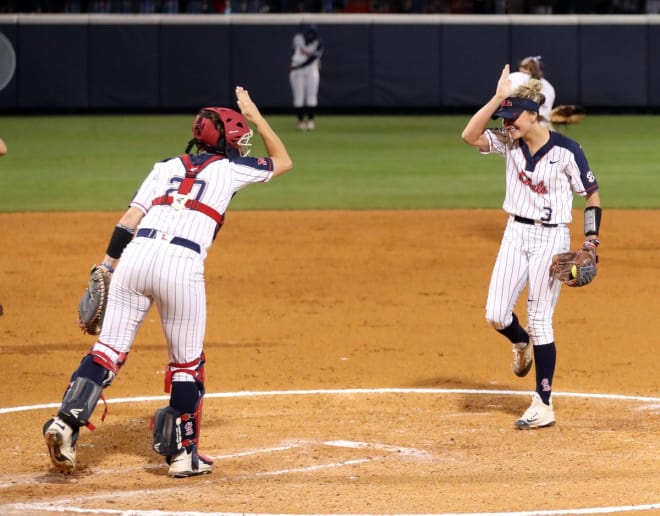Ole Miss pitcher Kaitlin Lee (3) and catcher Courtney Syrett throw up the "Landshark" during the Rebels' 8-0 NCAA tournament win over Southern Illinois Friday night.