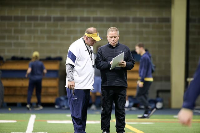 Mike Elko (left), with Brian Kelly, is Notre Dame's 12th defensive coordinator in title since 1990.