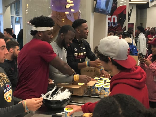 FSU tight end Tre' McKitty (from left), tailback Jacques Patrick and wide receiver Auden Tate hand out Frozen Lemonade treats to students Monday evening in the Champions Club.