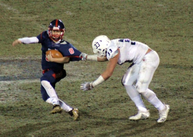Eastside Catholic defensive end J.T. Tuimoloau pulls down Centennial quarterback Jonathan Morris for one of his five sacks during a 17-0 victory over the Coyotes.  The teams met in the GEICO State Champions Bowl Series in Peoria on Saturday night.