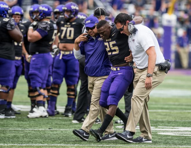 James Madison running back Cardon Johnson is helped off the field during the Dukes' win over Norfolk State last season.