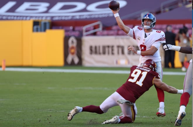 New York Giants quarterback Daniel Jones (8) passes the ball while being hit by Washington Football Team defensive end Ryan Kerrigan (91) in the third quarter at FedExField.