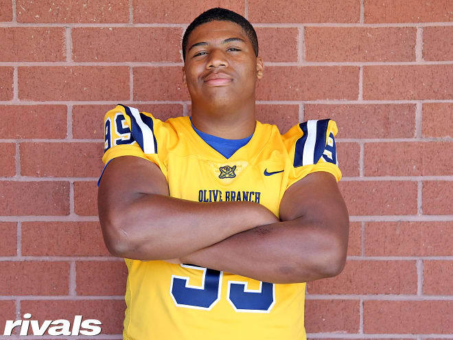 Five-star defensive tackle Walter Nolen holds a Michigan Wolverines football recruiting, Jim Harbaugh.