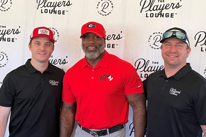At the Chimney Oaks Golf Club, Ty Frix (left) and Aaron Leicht (right) of The Players' Lounge surround Chris Milton, father of current UGA player Kendall Milton.