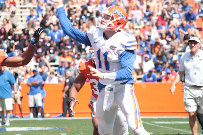 Florida quarterback Kyle Trask makes a throw while Dan Mullen looks on.