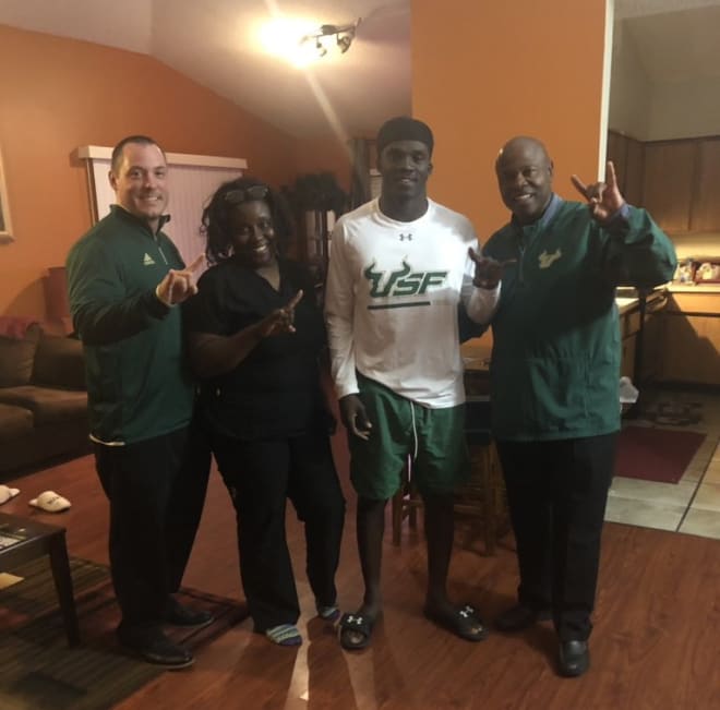 Logan poses with USF coaches during an in-home visit last week