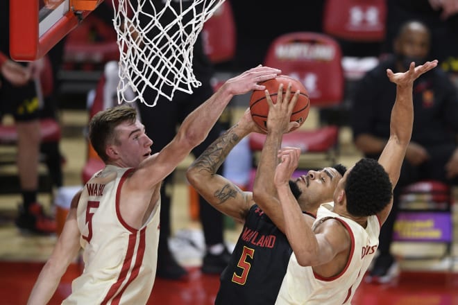 Maryland guard Eric Ayala (5) goes to the basket against Wisconsin forward Tyler Wahl (5) and guard Jonathan Davis (1) during Wisconsin's 61-55 victory.