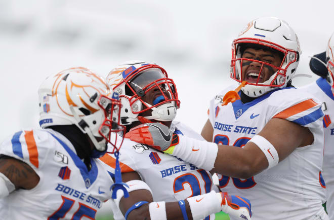 Boise State defensive back Tyreque Jones, center, celebrates intercepting a pass with cornerback Jalen Walker, left, and linebacker Curtis Weaver in the first half of an NCAA college football game against Colorado State Friday, Nov. 29, 2019, in Fort Collins, Colo.