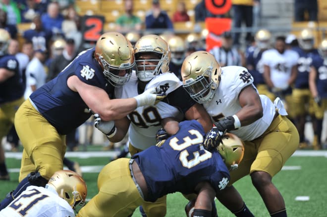 Defensive back Jalen Elliot (21), defensive lineman Jerry TIllery (99) and linebacker Nyles Morgan (5) combine on the tackle to take down running back Josh Adams.