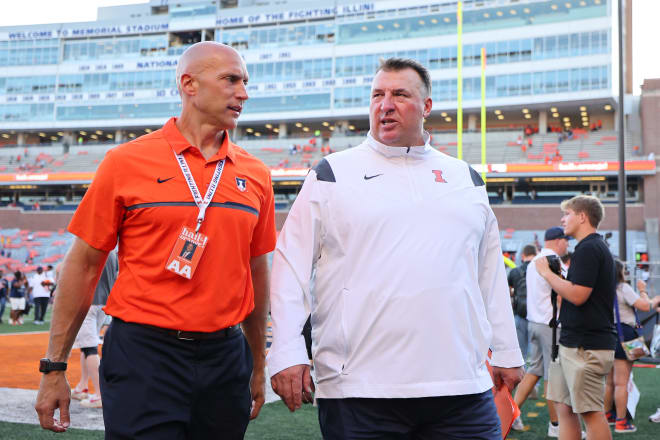  Illinois Fighting Illini Athletic Director Josh Whitman talks with head coach Bret Bielema after they defeated the Wyoming Cowboys 38-6 at Memorial Stadium on August 27, 2022 in Champaign, Illinois.