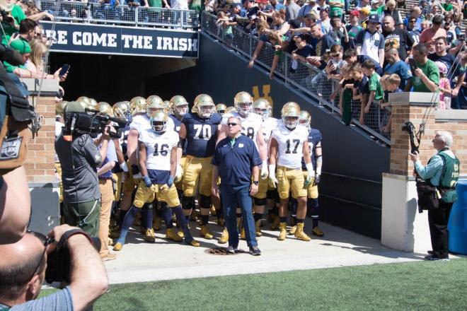 Notre Dame football head coach Brian Kelly leading his team onto the field prior to a game