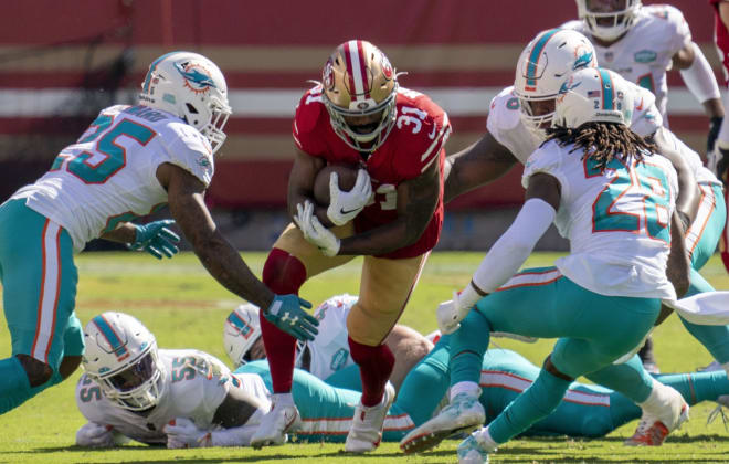 San Francisco 49ers running back Raheem Mostert (31) is tackled by Miami Dolphins cornerback Xavien Howard (25) and strong safety Bobby McCain (28) during the second quarter at Levi's Stadium.