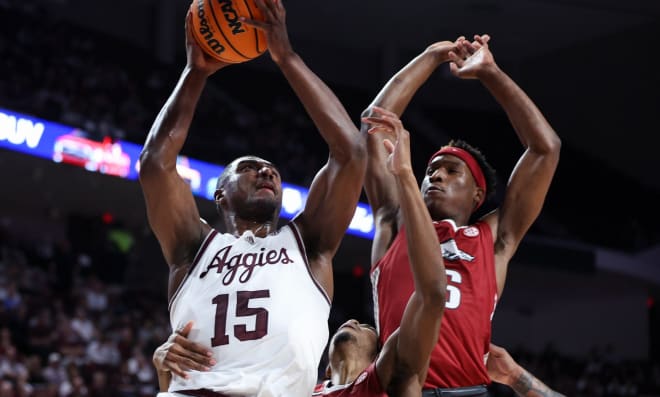 Texas A&M's Henry Coleman III goes for a basket against Arkansas freshman Layden Blocker during Tuesday's game at Reed Arena in College Station, Texas.