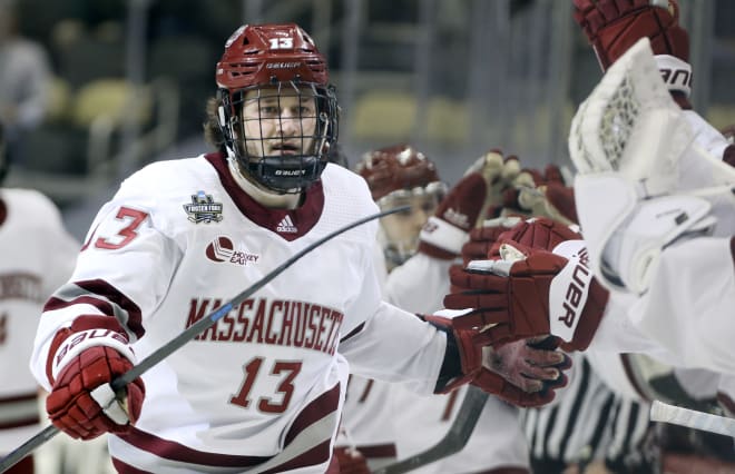 Pittsburgh, PA, USA; U.Mass Minutemen forward Reed Lebster (13) celebrates his goal against the St. Cloud State Huskies with the Minutemen bench during the first period in the championship game of the 2021 Frozen Four NCAA hockey tournament at PPG Paints Arena.