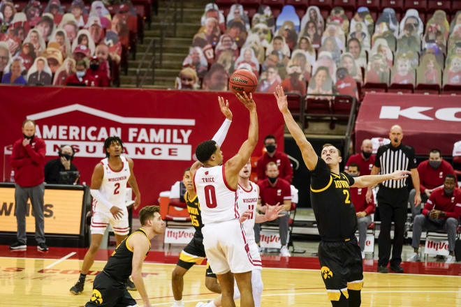 D'Mitrik Trice (0) attempts a shot over Iowa's Jack Nunge. Trice went 3-for-15 from the floor in the 77-62 loss to the Hawkeyes.