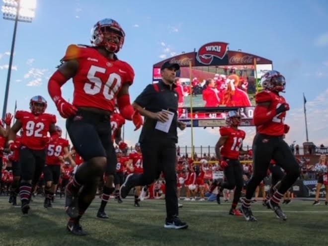 Coach Tyson Helton and his players run onto the field as they get prepared for a home game,