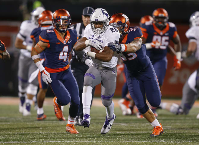 Jeremy Larkin #28 of the Northwestern Wildcats runs the ball as Tre Watson #33 of the Illinois Fighting Illini makes the grab for the stop at Memorial Stadium on November 25, 2017 in Champaign, Illinois.