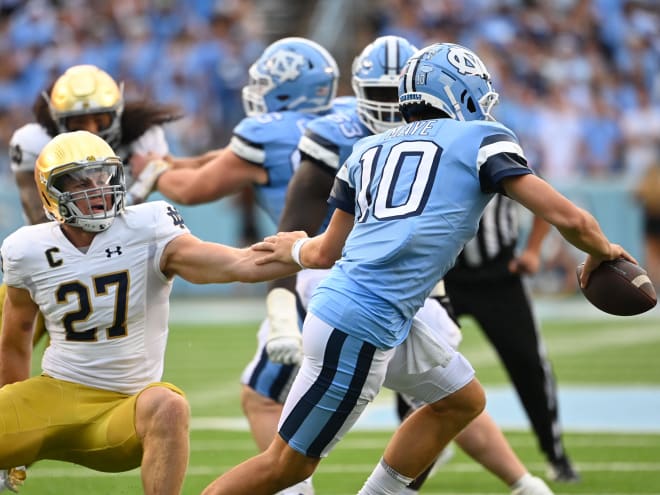 Notre Dame linebacker JD Bertrand (27) tries to bring down North Carolina quarterback Drake Maye.