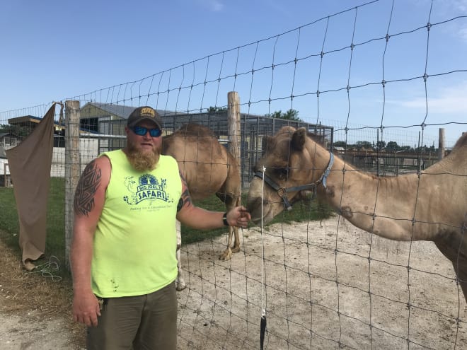 Joel Clinger poses with D.C., one of the two camels at Big Joel's Safari.