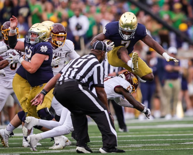 Notre Dame running back Audric Estimé (7) hurdles a defender on his way to a career-high 174 rushing yards.