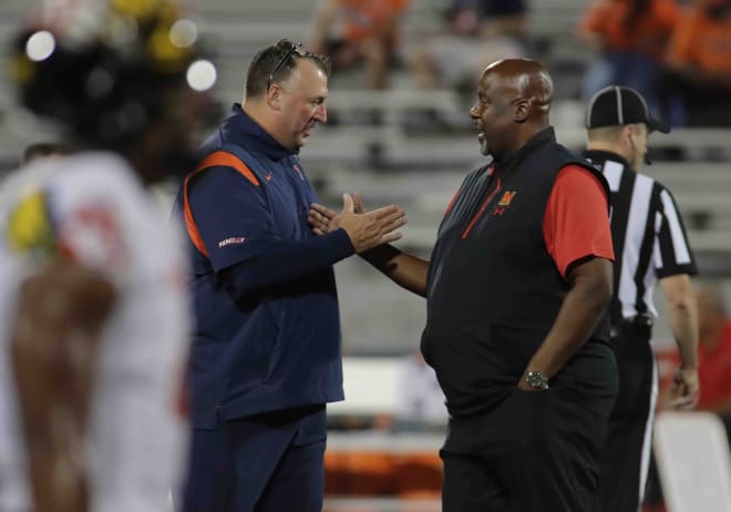 Illinois Fighting Illini head coach Bret Bielema, left, and Maryland Terrapins head coach Mike Locksley shake hands before the start of their game, Friday at Memorial Stadium.