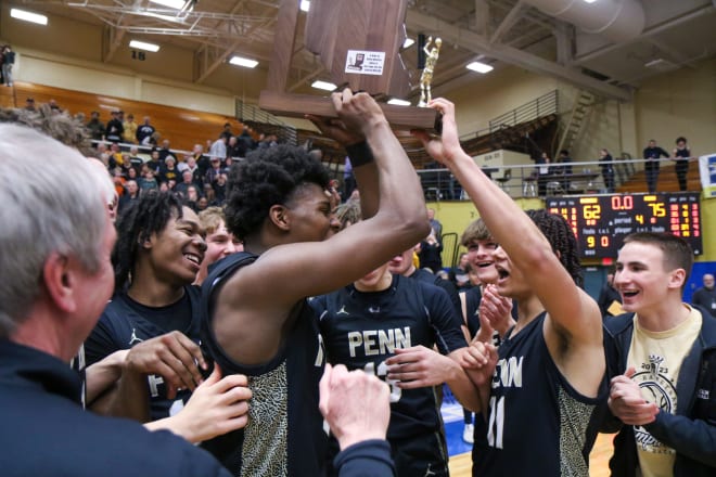 Markus Burton (center) and his Penn High teammates celebrate a basketball sectional title.