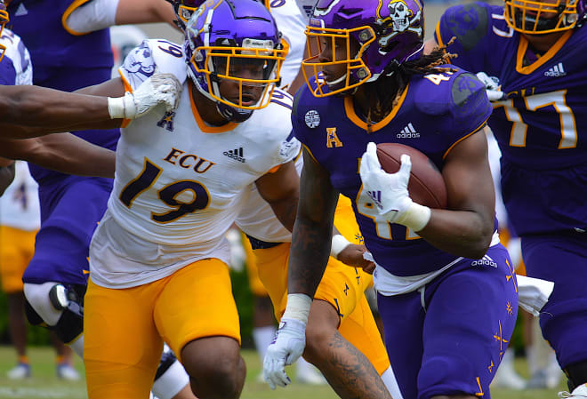 ECU running back Rahjai Harris is chased by Jacoby Simpson in Saturday's Purple-Gold Spring Game
