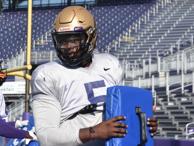 James Madison defensive end Ron'Dell Carter holds a pad as he listens to instructions during a drill earlier this month at Bridgeforth Stadium.