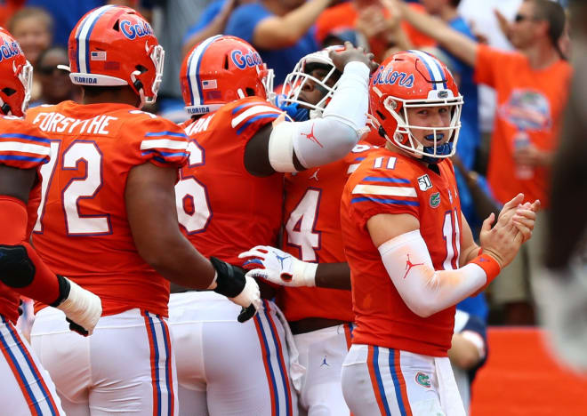 Florida quarterback Kyle Trask (far right) and the offense celebrate a touchdown by Kyle Pitts.