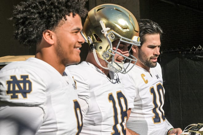 Notre Dame QBs Kenny Minchey (8), Steve Angeli (18) and Sam Hartman (10) gather together ahead of ND's 31-23 loss at Clemson on Saturday.