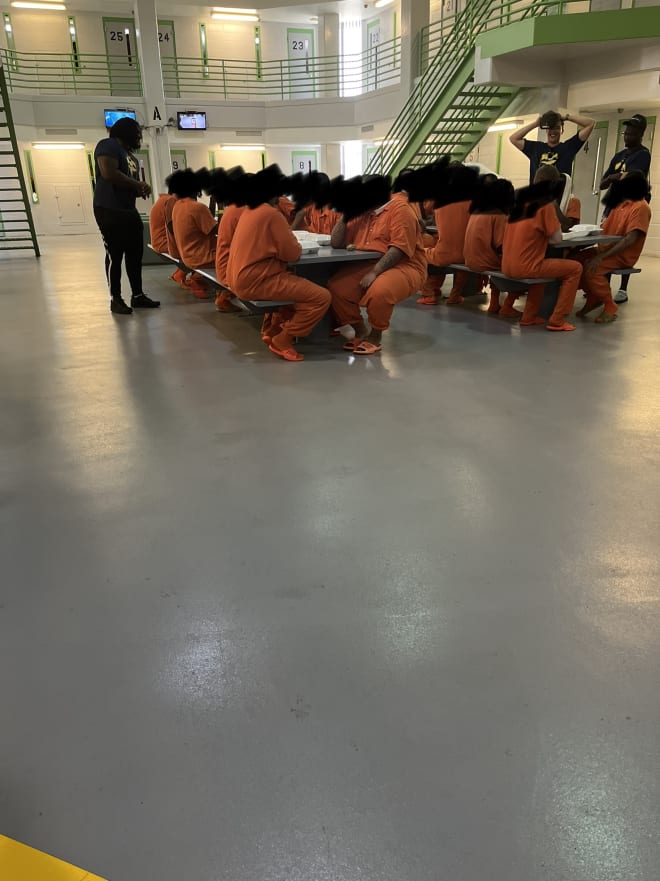 Mazi Smith (left), Cade McNamara (right), and Mike Sainristil (right) speak with inmates at the Genesee County Jail on Thursday afternoon. (Brandon Justice/Rivals)