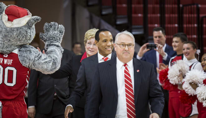 Chancellor Randy Woodson (front) leads Keatts (middle) and AD Debbie Yow onto the court at historic Reynolds Coliseum.