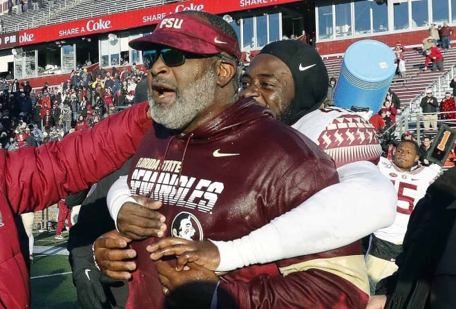 Odell Haggins is hugged by FSU players after Saturday's win at Boston College.