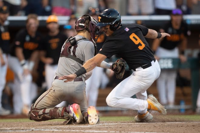 Tennessee's Hunter Ensley (9) slides safely to home past Texas A&M’s Jackson Appel (20) during game three of the NCAA College World Series finals between Tennessee and Texas A&M at Charles Schwab Field in Omaha, Neb., on Monday, June 24, 2024.