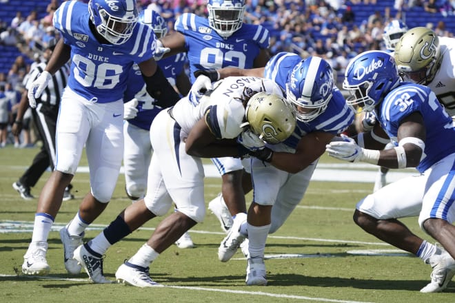 Jordan Mason tries to break a tackle against Duke