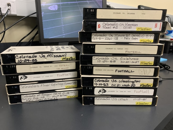 Many older recordings of CU games were done on film, such as the Colorado vs. Missouri game from October of 1955, shown atop the stack of VHS tapes on the left. In the 1990s, they were converted from film to VHS, the format from which Guy has now been digitizing them.   