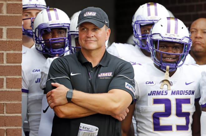 Second-year James Madison football coach Mike Houston smiles as he prepares to lead the Dukes onto the field before Saturday's opener at East Carolina.